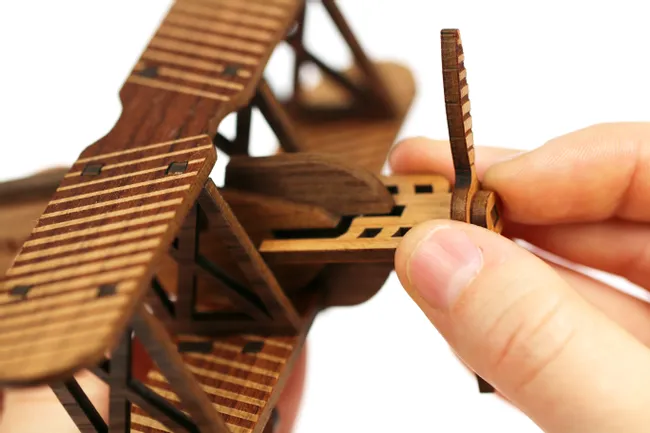 Assembling detailed wooden model plane cut with Trotec CO₂ laser cutter