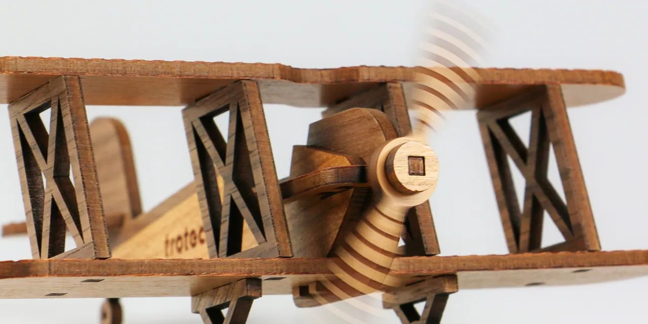 Wooden biplane model cut with Trotec laser cutter showing fine detail and moving propeller