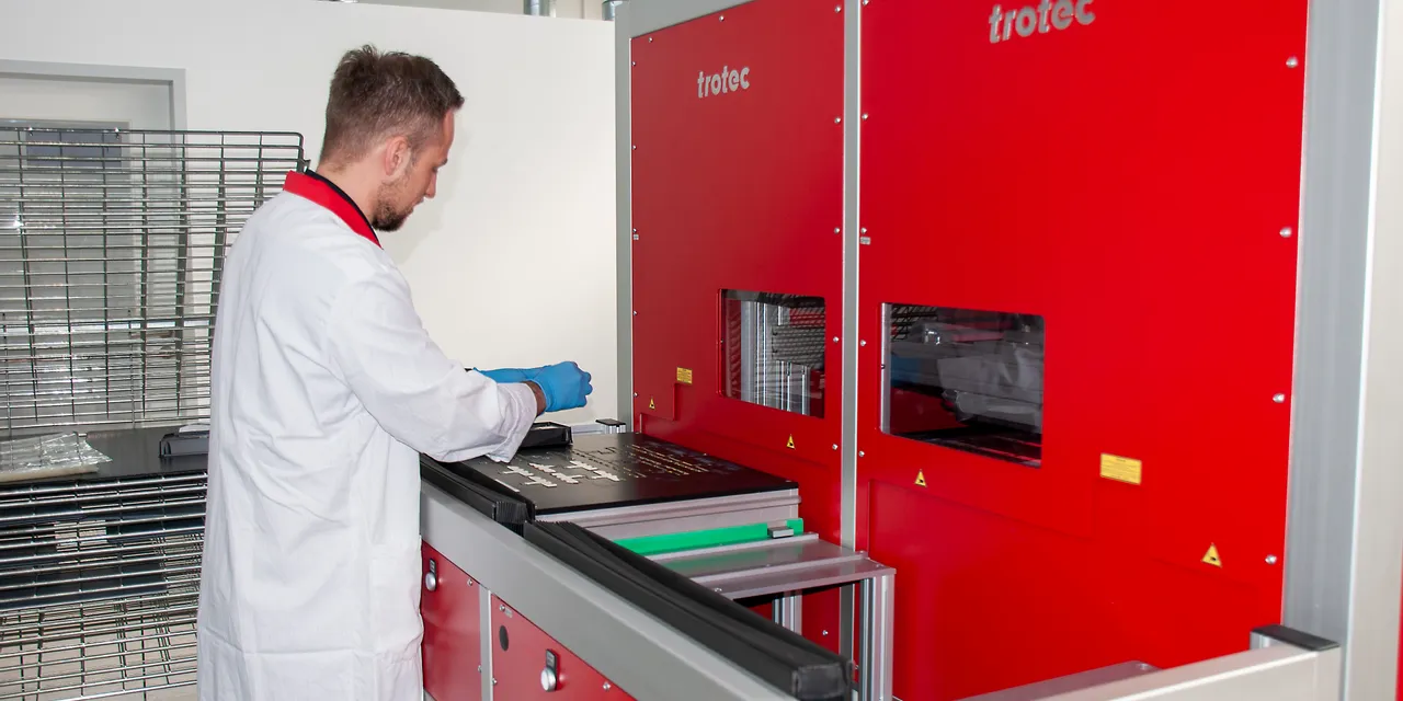 Operator using Trotec SpeedMarker laser marking system for precise industrial engraving tasks
