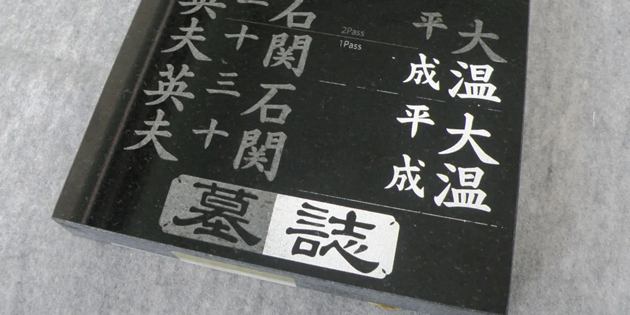 Trotec laser engraver etching detailed Japanese characters on black granite sample