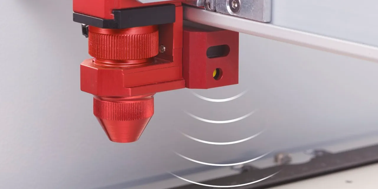 Close-up of Trotec Speedy series CO₂ laser cutter head with autofocus sensor in operation