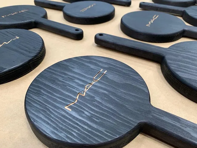 Laser-engraved black wooden hand mirrors with MAC logo using Trotec CO₂ laser cutter
