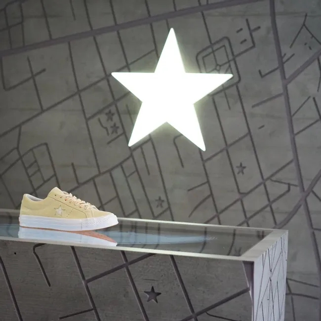 Laser-engraved map display with illuminated star and beige sneaker on Trotec-cut surface