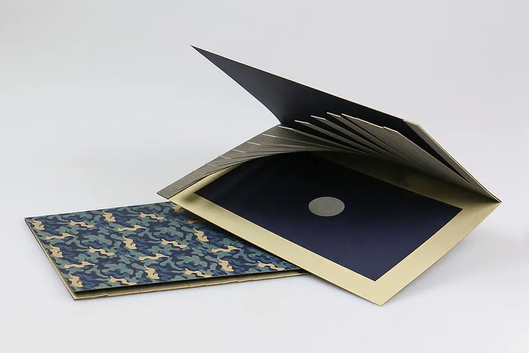 Laser-cut custom brochure with camouflage cover and precision-cut inserts using Trotec laser cutting technology