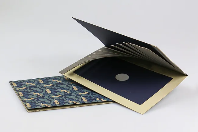 Laser-cut custom brochure with camouflage cover and precision-cut inserts using Trotec laser cutting technology