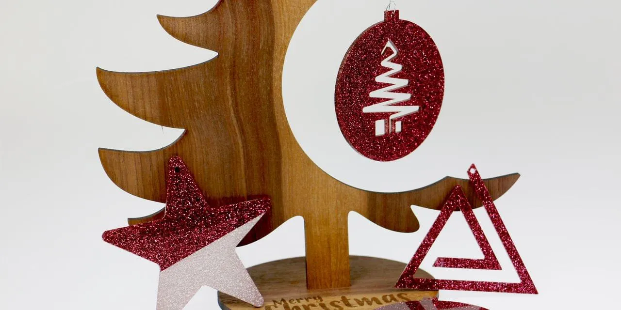 Laser-cut wooden Christmas tree with red glitter ornaments made using Trotec laser cutter
