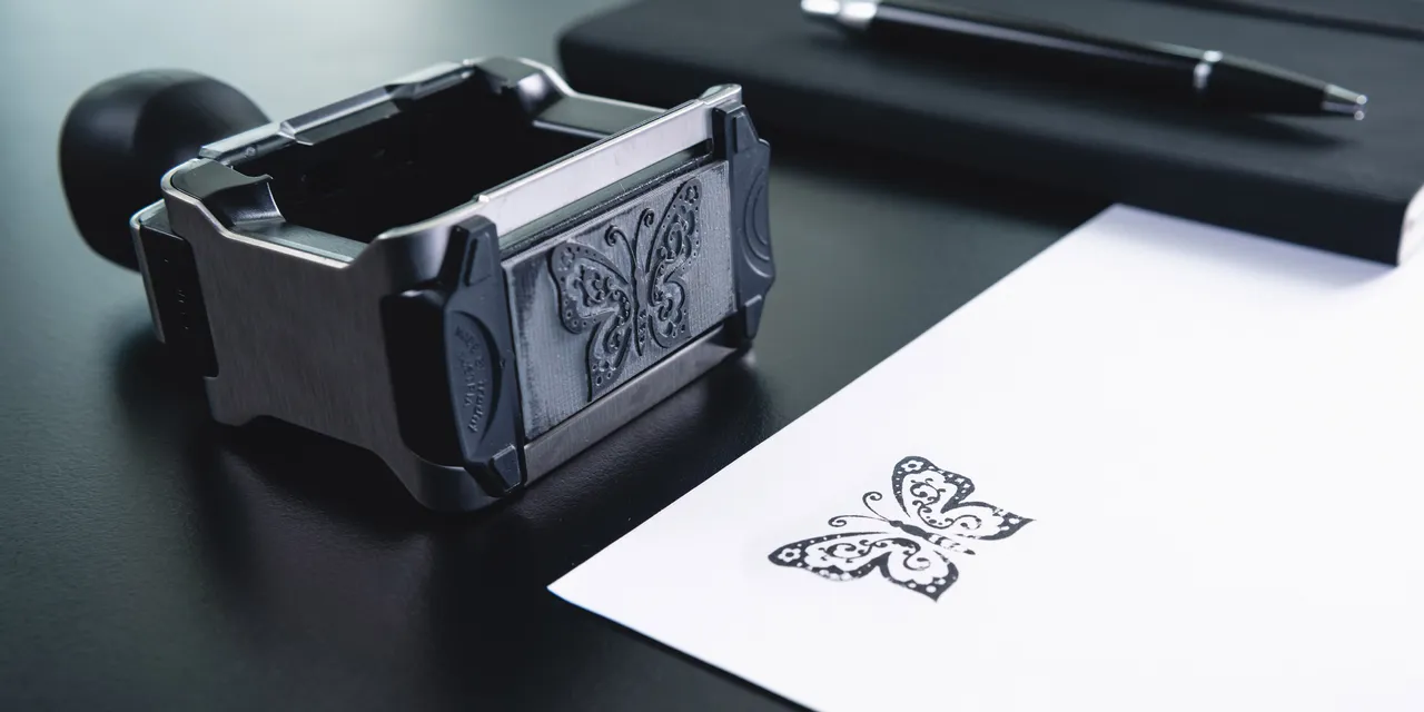 Laser-engraved butterfly stamp design on paper using Trotec laser engraving technology
