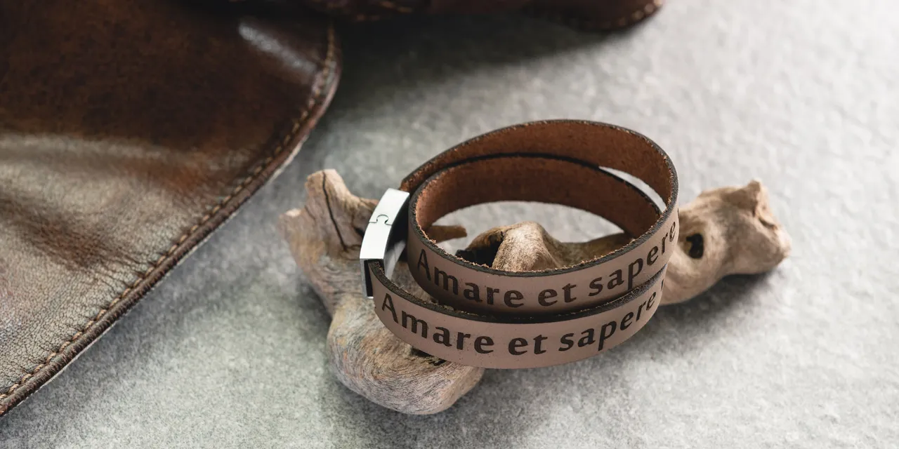 Laser-engraved leather bracelet with Latin text created using Trotec CO₂ laser cutter