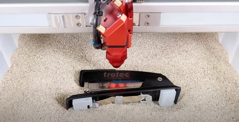 Trotec laser cutter engraving logo on black stapler using CO₂ laser technology