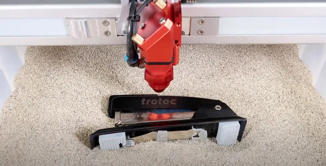 Trotec laser cutter engraving logo on black stapler using CO₂ laser technology