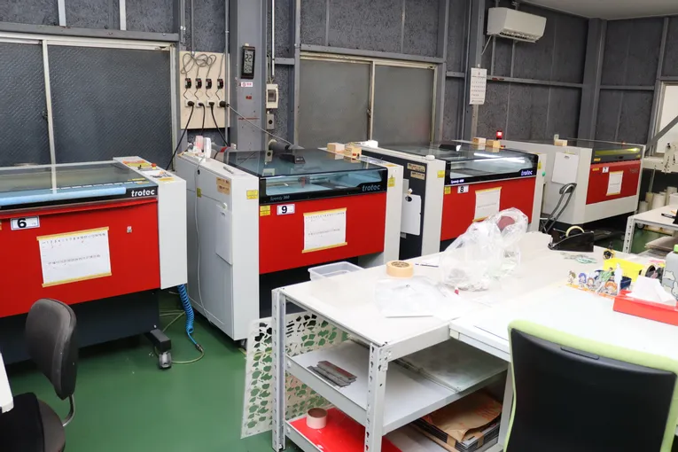 Multiple Trotec Speedy series CO₂ laser cutters in workshop production setup