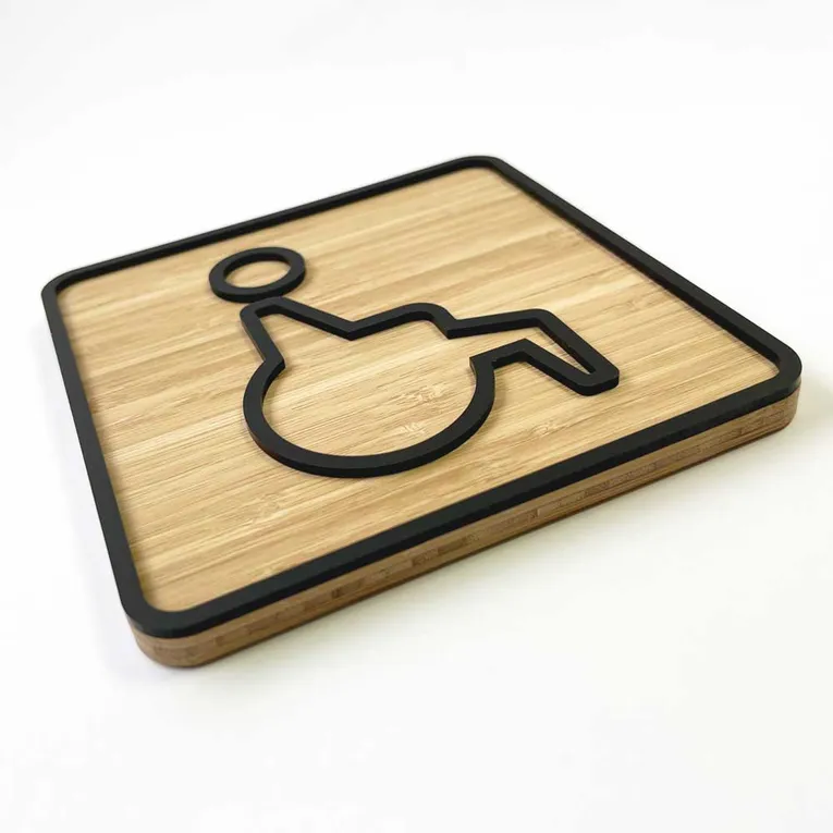 Trotec laser-cut bamboo wheelchair accessibility sign with precision-cut black acrylic inlay