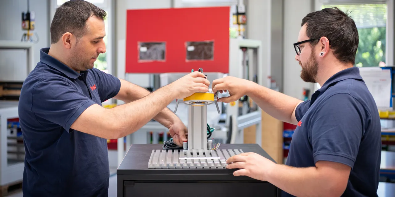 Technicians assembling Trotec laser marking system component in production facility