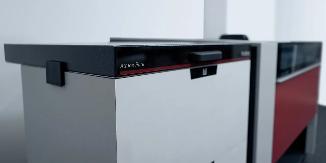 Trotec Atmos Pure exhaust system next to Speedy series laser cutter