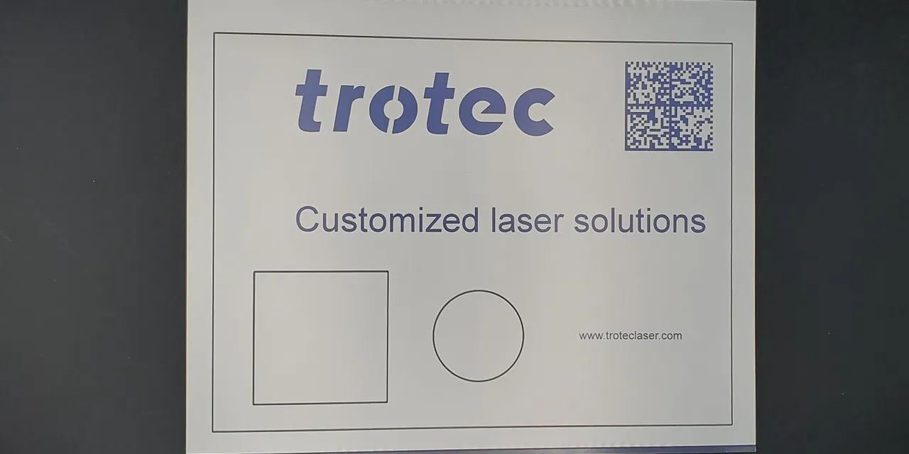 Trotec customized laser solutions sign with logo, QR code, and engraved shapes