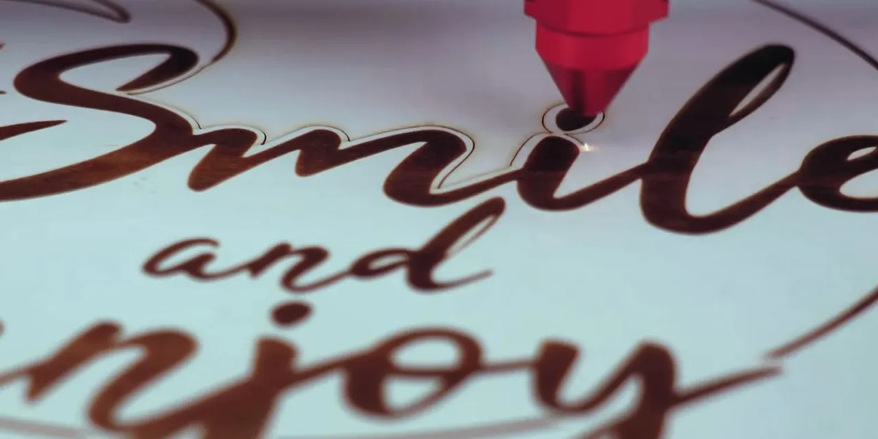 Trotec laser cutter engraving Smile and Enjoy design on wood with precise CO₂ laser