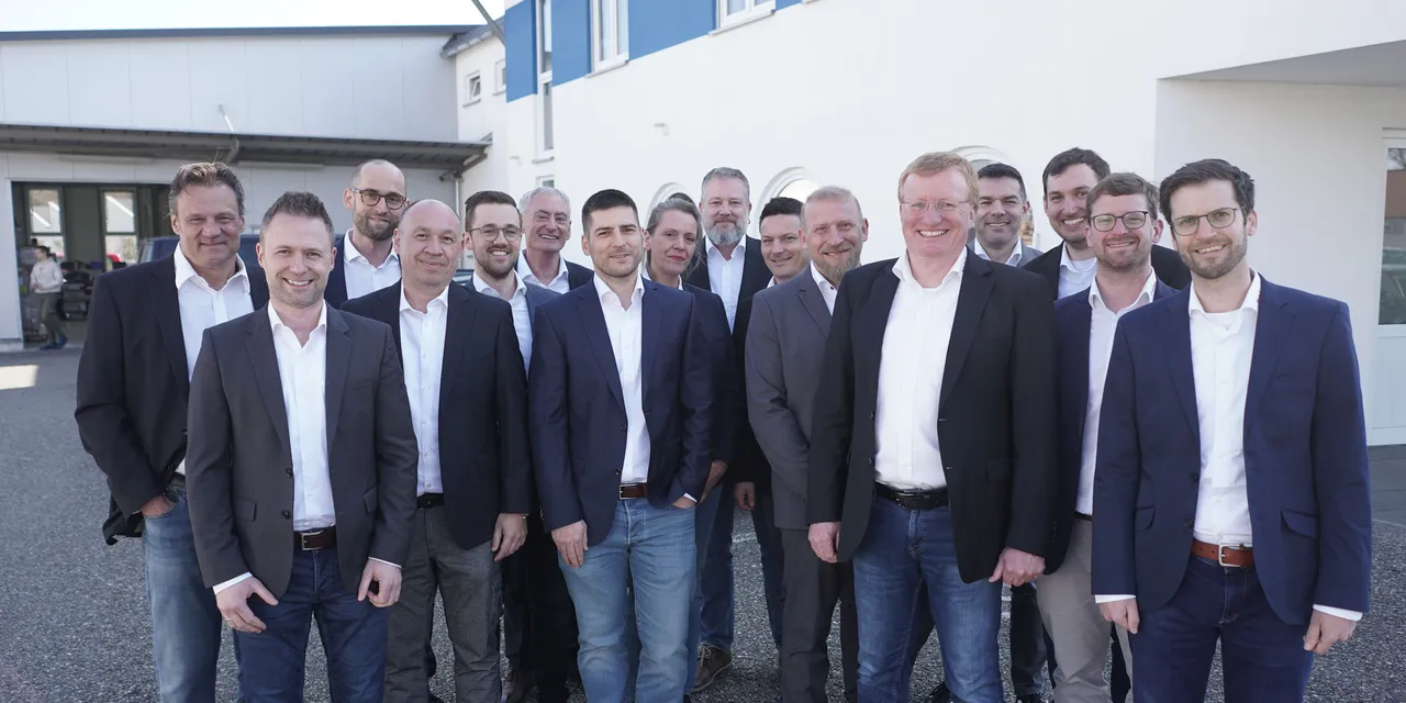 Trotec laser team members standing outside company building in business attire