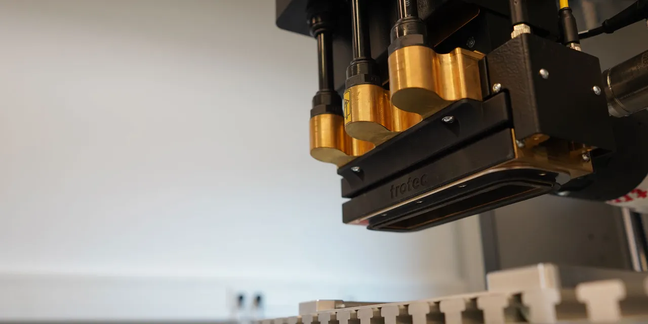 Trotec SpeedMarker laser marking machine head positioned above metal work surface