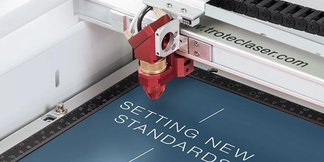 Trotec Speedy series laser cutter engraving text on blue material