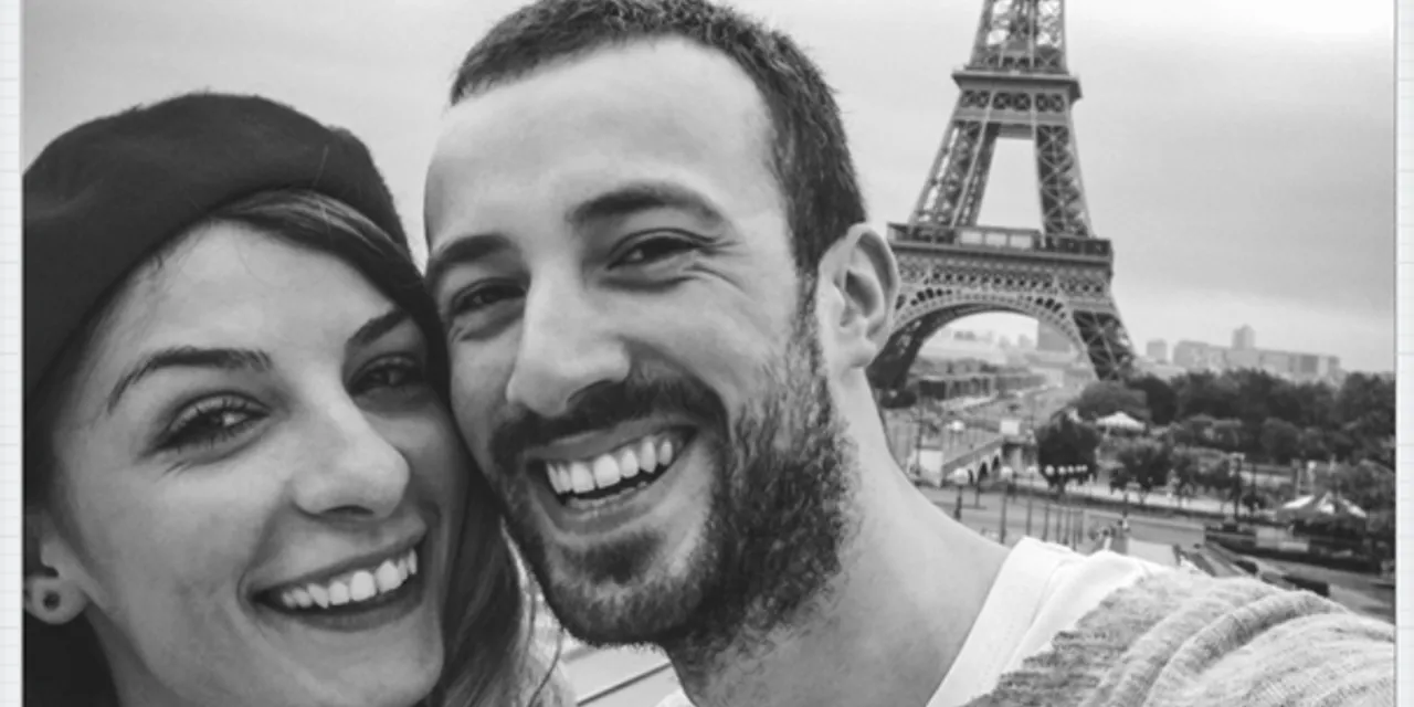 Smiling couple taking a selfie near the Eiffel Tower in Paris
