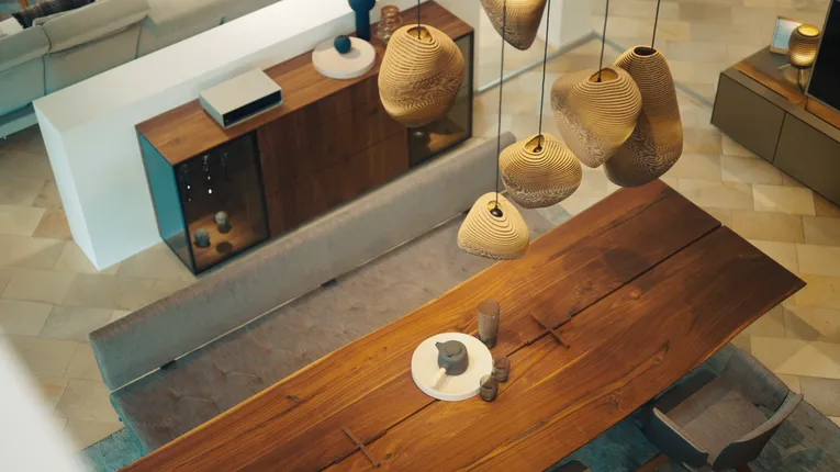 Modern dining room with wooden furniture and pendant lights, featuring laser-cut wooden lampshades